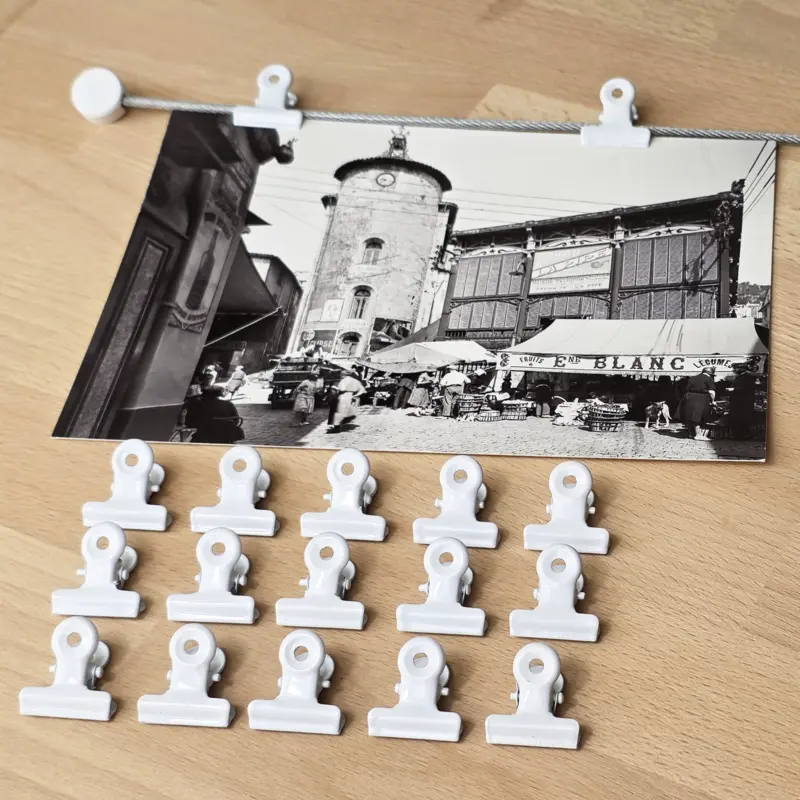Detailansicht vom Fotoseil mit weißen Clips und einer Postkarte