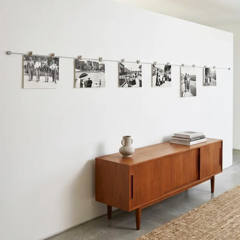 Minimalistisches Fotoseil mit weißen Clips an der Wand im Wohnzimmer